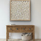 Turritella shell wall art in natural wood frame displayed above console table