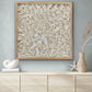 Turritella shell wall art in natural wood frame displayed above sideboard